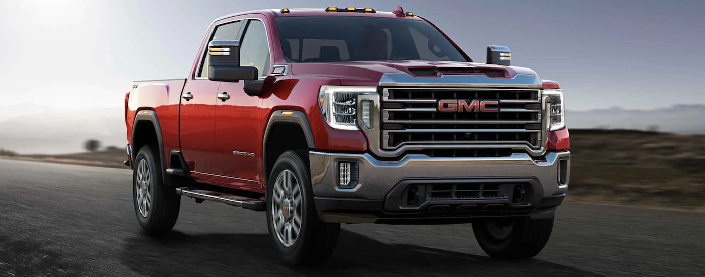 A red 2021 GMC Sierra 2500 driving a paved road.