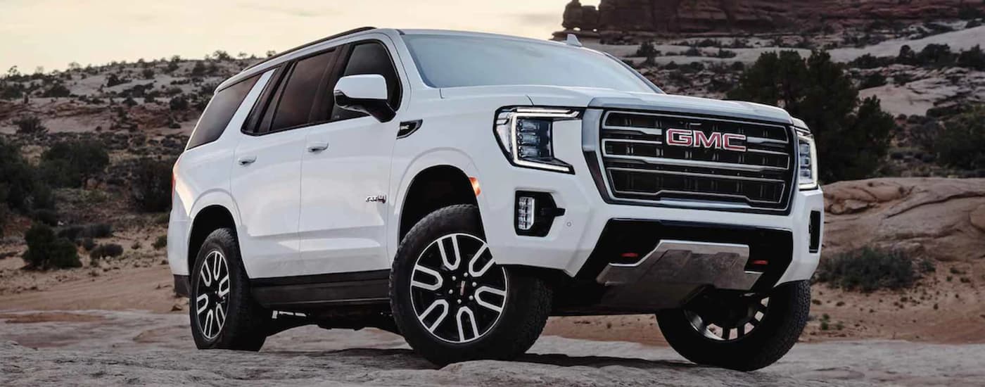 A white 2022 GMC Yukon shown parked on a rocky road.