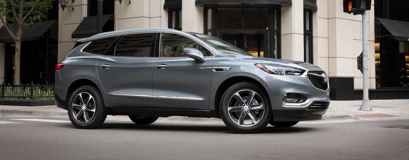 Silver 2021 Buick Enclave driving around a bend.