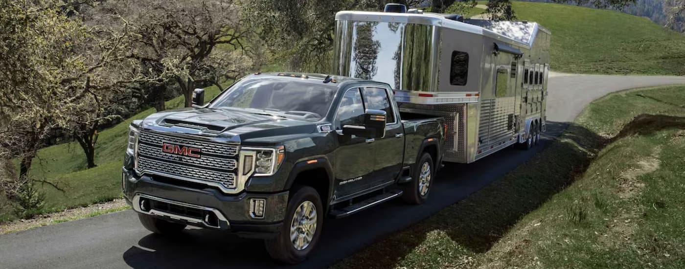Black 2024 GMC Sierra 2500 HD towing a camper
