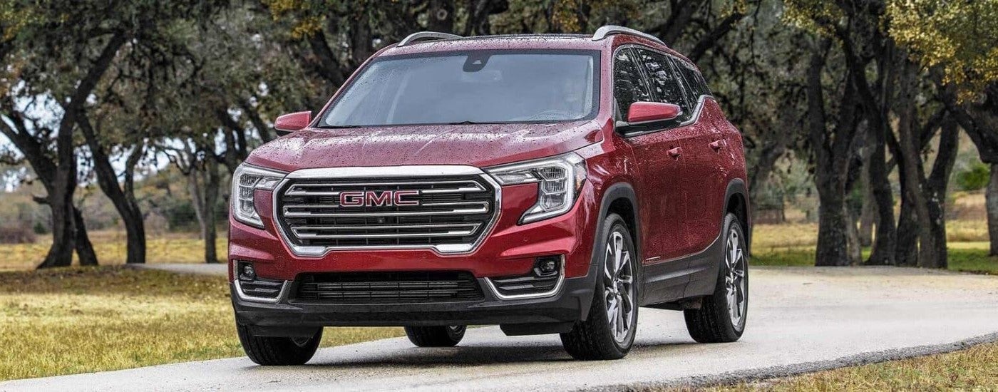 Red 2023 GMC Terrain SLT driving on a trail.