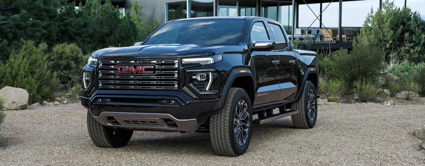 Black 2026 GMC Canyon Denali parked in front of a house