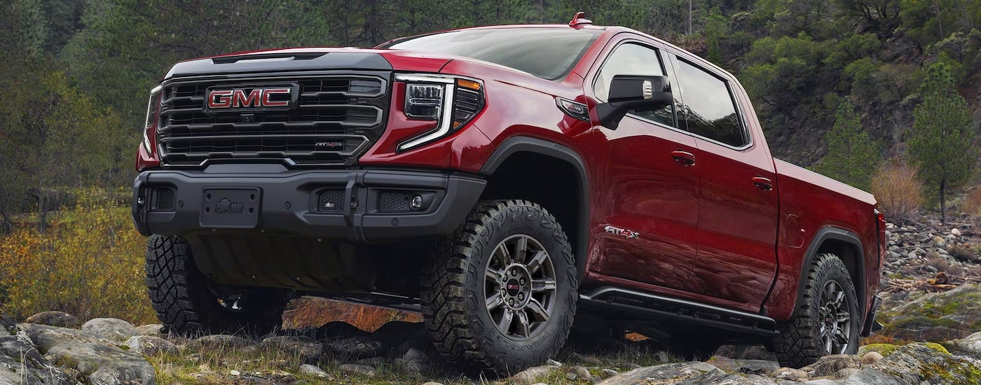 Red 2026 GMC Sierra 1500 parked off-road on a rocky hill