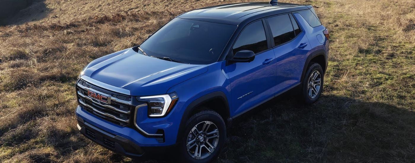 Aerial view of a blue 2026 GMC Terrain parked in a field.