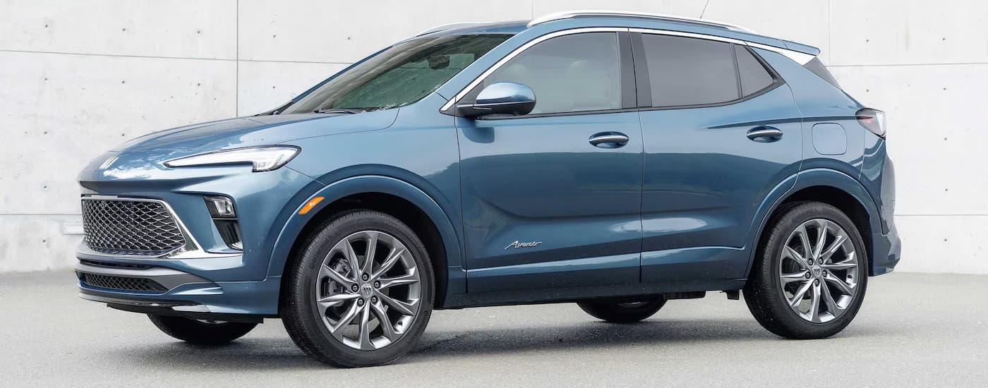Side of a blue 2026 Buick Encore GX parked in front of a wall.