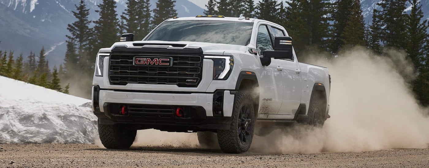 White 2026 GMC Sierra 2500 HD driving off-road.