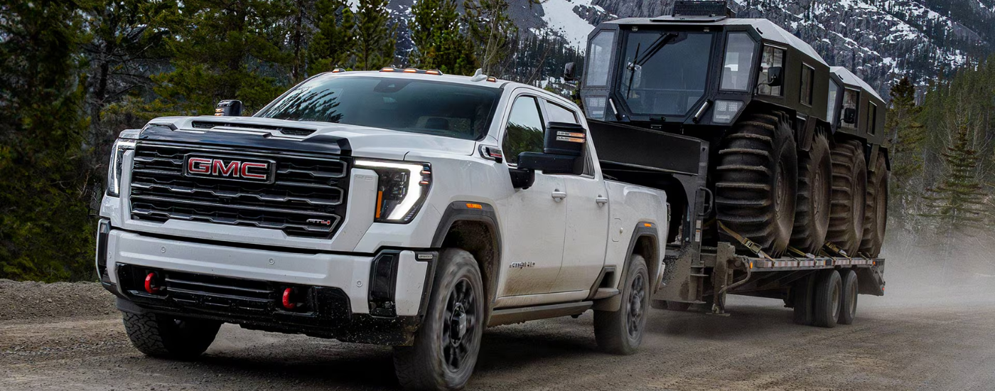 White 2026 GMC Sierra 2500 HD towing an ATV