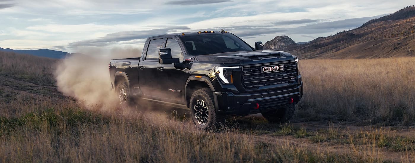 Black 2026 GMC Sierra 2500 HD AT4X driving off-road.