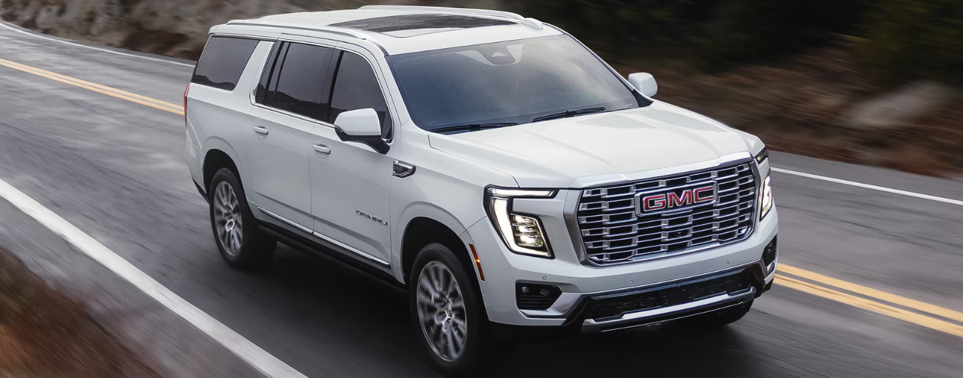 White 2026 GMC Yukon XL driving along an open road