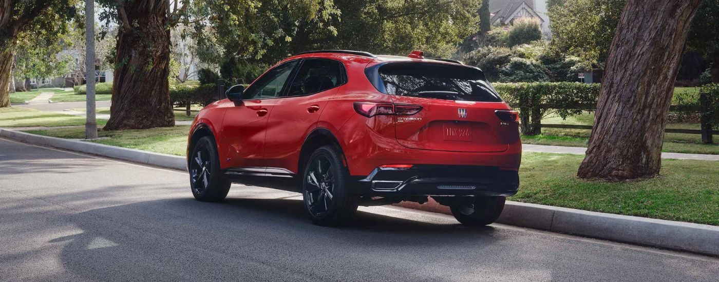 Three quarter rear view of a red 2026 Buick Envision parked on a neighborhood street.