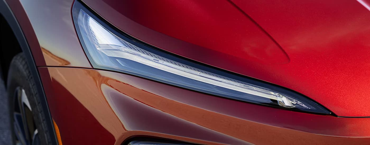 Headlight on an orange 2026 Buick Enclave at a dealer in Enterprise