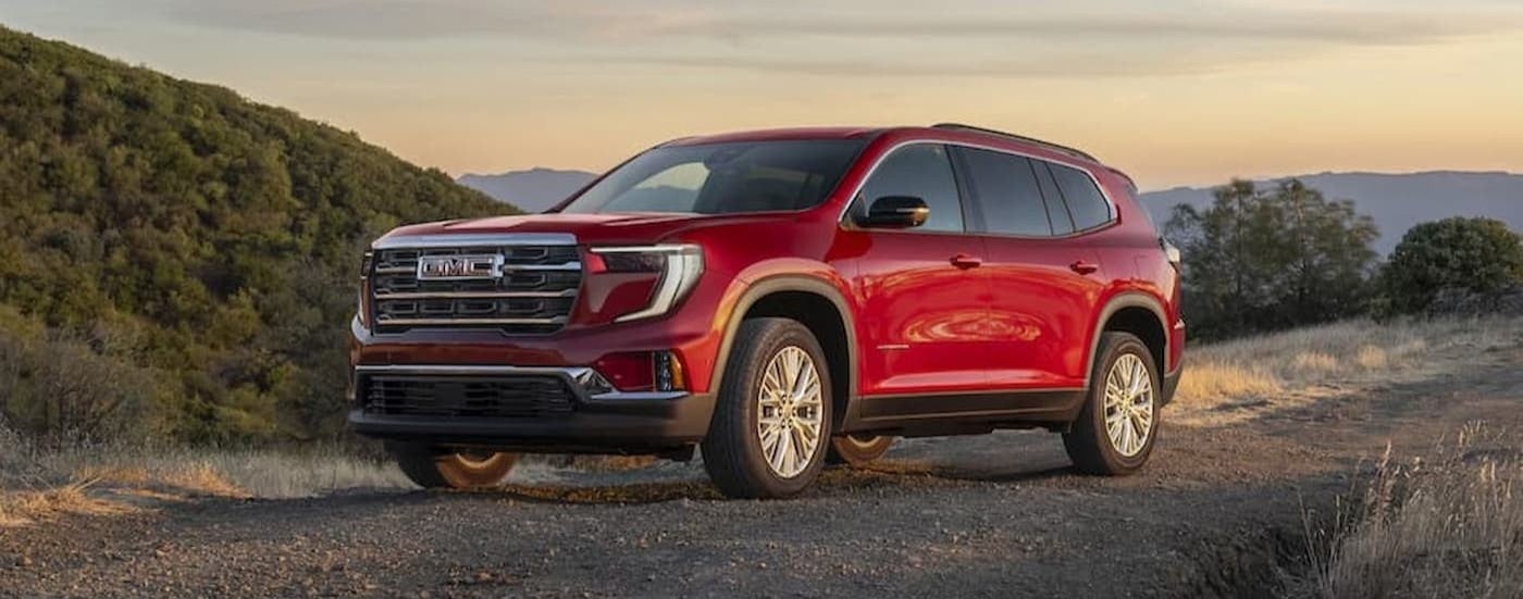 A red 2025 GMC Acadia parked offroad.