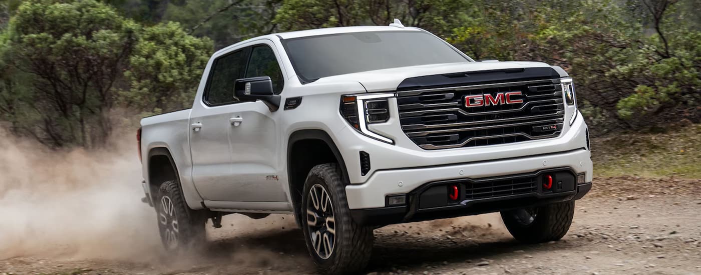 A white 2025 GMC Sierra 1500 Denali off-roading in dirt